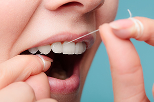 Close up of a woman’s teeth while flossing