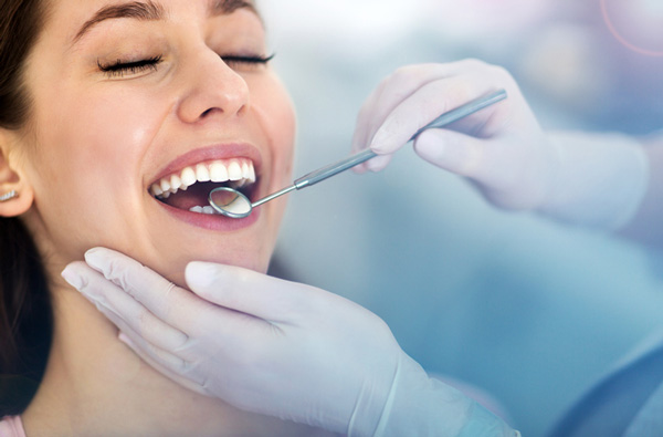 Woman getting dental exam by Dr. Sikka in Upland CA