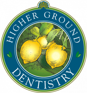 A round logo for Higher Ground Dentistry featuring three yellow lemons with green leaves in the center, bordered by blue and green rings with the business name in white letters.