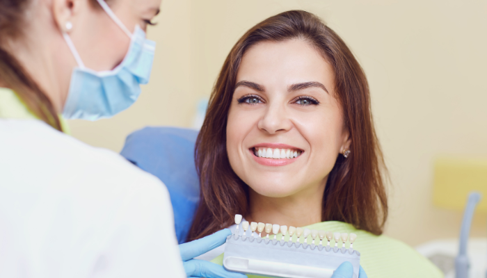 Happy woman smiling in dental chair showing cosmetic dentistry myths debunked with confident beautiful natural smile