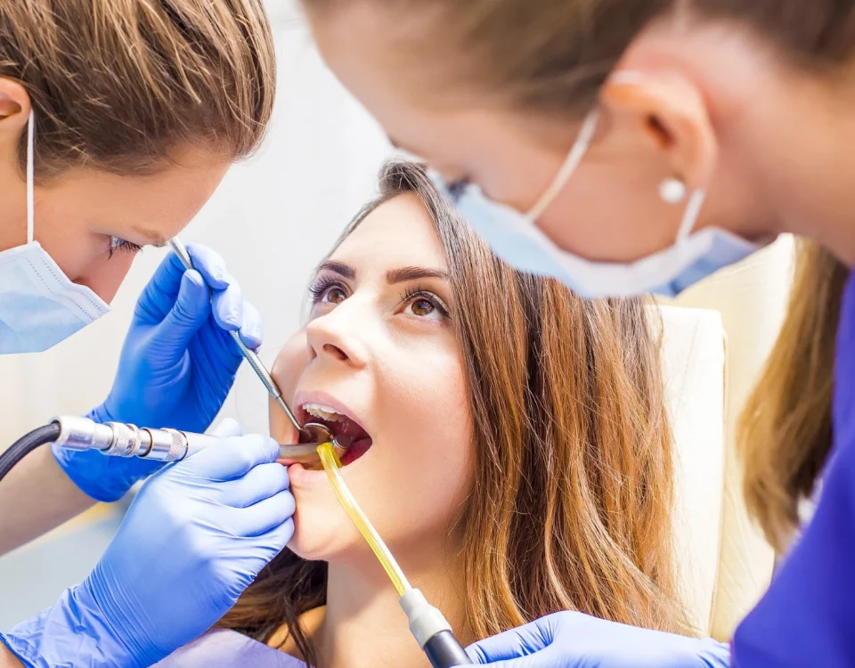 Dentist examining patient’s teeth to check why some people get cavities more easily than others.