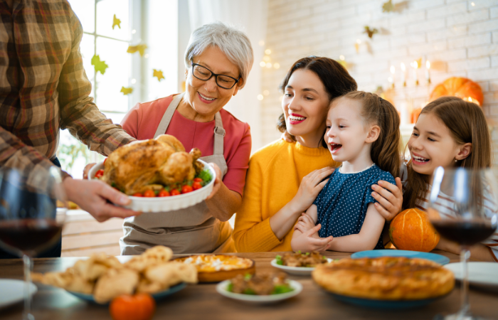 Family enjoying a holiday meal together with bright, healthy smiles — perfect inspiration for a Holiday Smile Makeover.