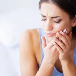 Woman suffering from severe tooth pain needing emergency dental care Upland, CA.