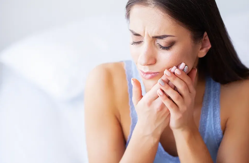 Woman suffering from severe tooth pain needing emergency dental care Upland, CA.