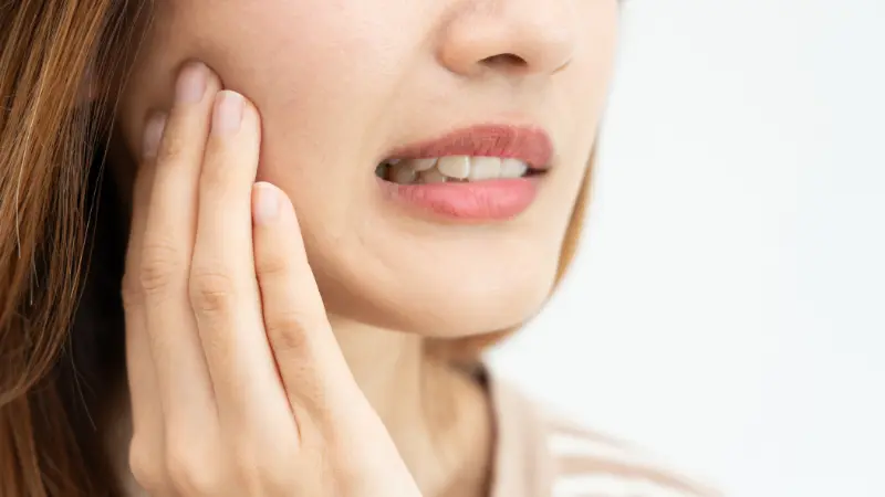 Woman with tooth pain seeking weekend emergency dentist in Upland for immediate relief