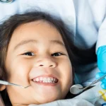 A friendly dentist at Higher Ground Dentistry in Upland showing a dental cleaning instrument to a child during a routine dental checkup for kids.