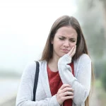Woman holding jaw in toothache pain looking for upland emergency dentist at Higher Ground Dentistry in Upland CA