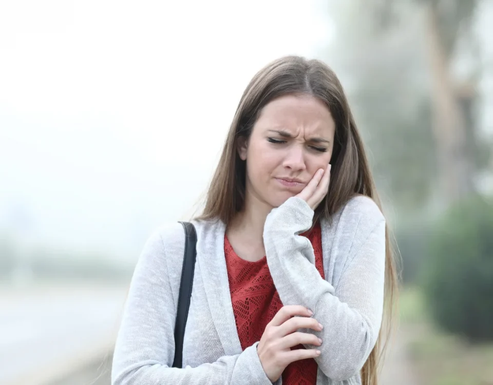 Woman holding jaw in toothache pain looking for upland emergency dentist at Higher Ground Dentistry in Upland CA