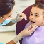 Dentist examining young girl's teeth representing kids dental care upland and cavity prevention upland ca at Higher Ground Dentistry