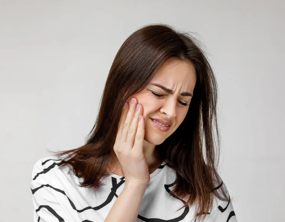 Woman experiencing pain from a swollen gum around one tooth